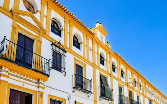 Seville historic building facade with yellow trim on self-guided walking tour.