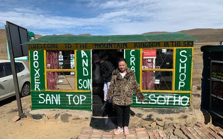 Sani Pass Lesotho shop with visitors, showcasing local crafts and mountain views.