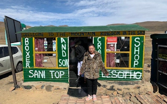 Sani Pass Lesotho shop with visitors, showcasing local crafts and mountain views.