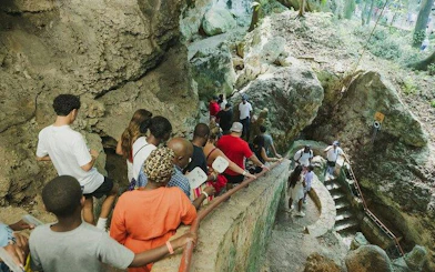 Visitors descending stone steps in a lush cave setting during Santo Domingo day tour from Punta Cana.