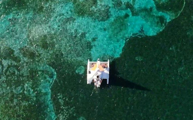 Catamaran sailing over clear waters in Punta Cana with guests enjoying the floating bar.