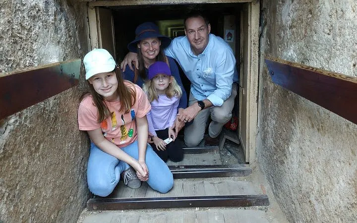 Family exploring a narrow passage inside the Giza Pyramid during a guided tour in Egypt.