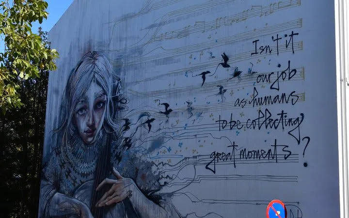 Reykjavik mural with artistic portrait and thought-provoking text on a guided street art tour.