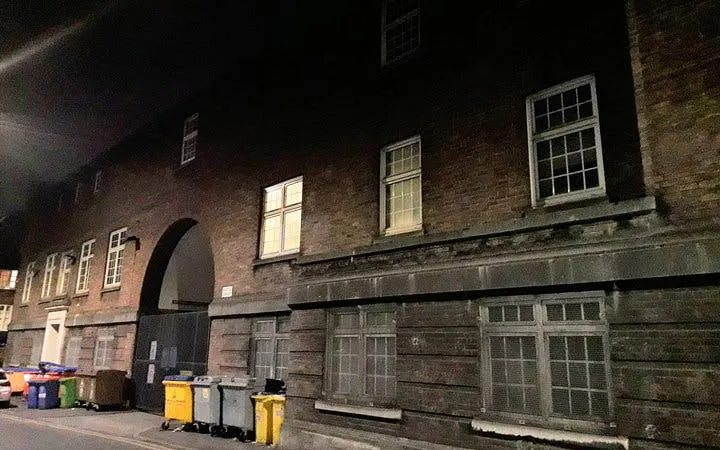 Haunted Manchester tour location with dimly lit historic building and alleyway.