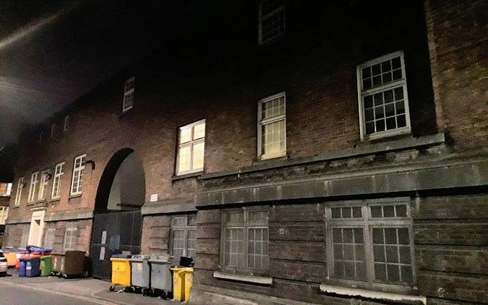 Haunted Manchester tour location with dimly lit historic building and alleyway.