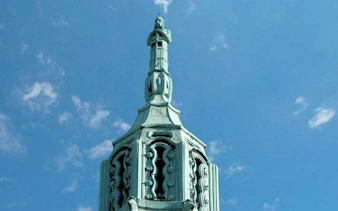 Debrecen building spire against blue sky on self-guided audio walking tour.