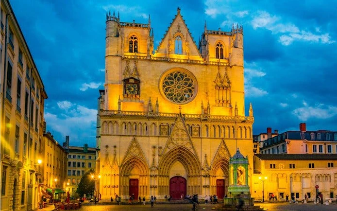 Saint-Jean Cathedral illuminated at dusk in Lyon, France, part of the Haunted Lyon exploration game.
