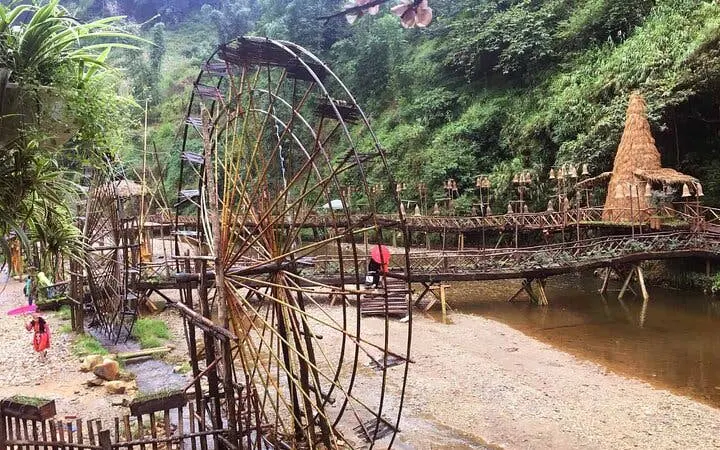 Bamboo water wheels and bridge in Sapa ethnic village, Vietnam, part of motorbike sightseeing tour.