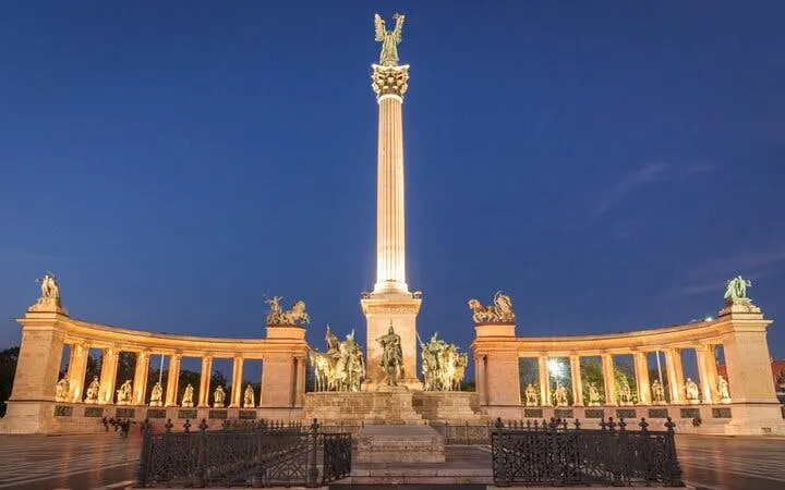 Heroes' Square in Budapest illuminated at night, part of the Ghosts of Budapest exploration game.