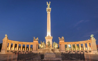 Heroes' Square in Budapest illuminated at night, part of the Ghosts of Budapest exploration game.