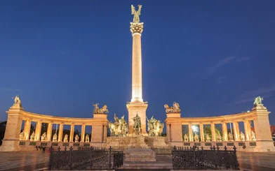 Heroes' Square in Budapest illuminated at night, part of the Ghosts of Budapest exploration game.