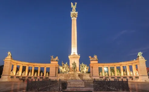 Heroes' Square in Budapest illuminated at night, part of the Ghosts of Budapest exploration game.
