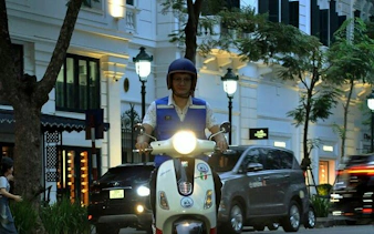 Vespa rider on Hanoi street during night food tour.