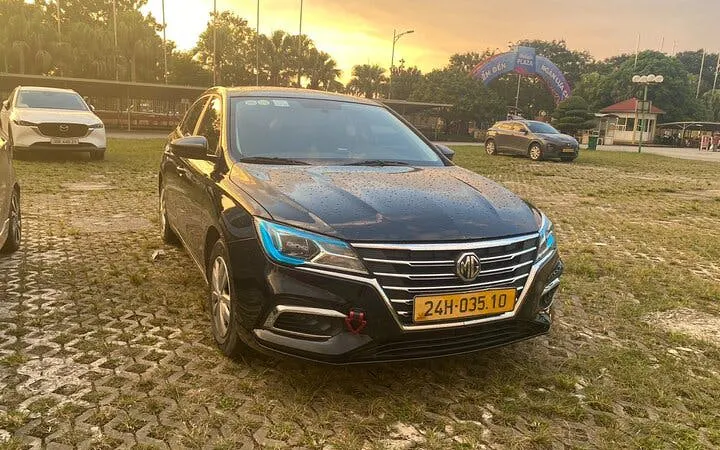 Private car parked on a cobblestone lot at sunset, Mu Cang Chai to Sa Pa transfer.