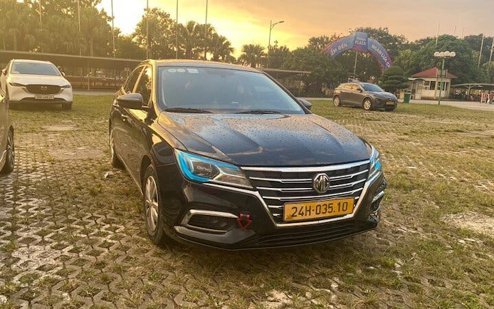 Private car parked on a cobblestone lot at sunset, Mu Cang Chai to Sa Pa transfer.