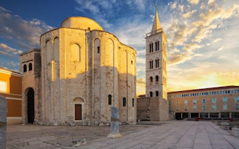 Zadar's Church of St. Donatus and bell tower at sunset, featured in self-guided walking tour app.