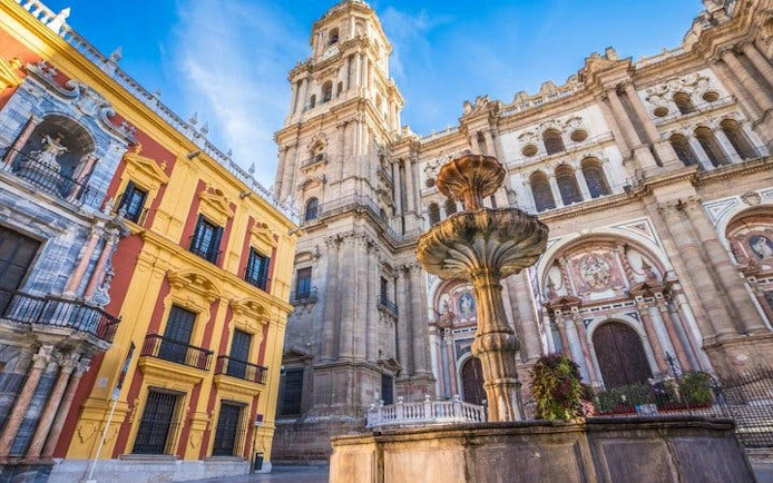 Malaga Cathedral and fountain on a sunny day, part of self-guided walking tour.