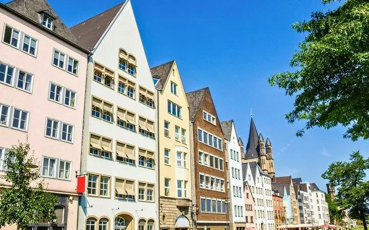 Colorful historic buildings along a street in Cologne, Germany, featured in a self-guided walking tour.