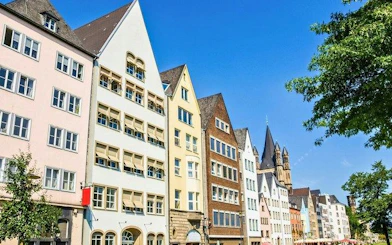 Colorful historic buildings along a street in Cologne, Germany, featured in a self-guided walking tour.