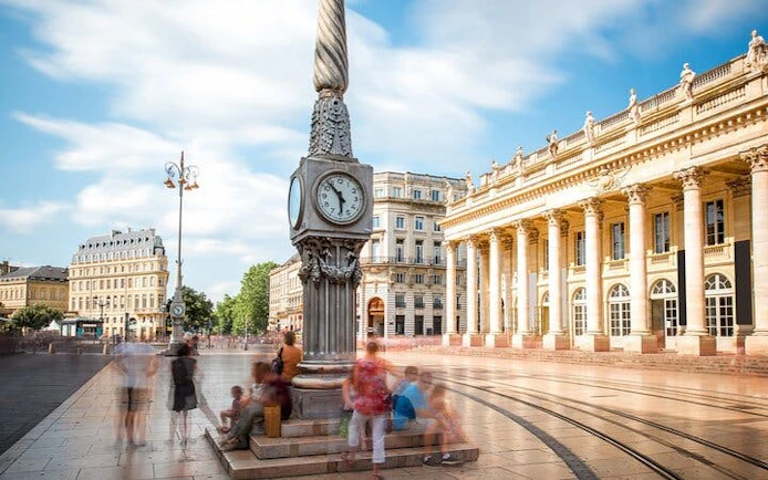 Old Town Bordeaux clock tower and Grand Théâtre with people exploring.