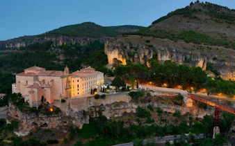 Cuenca's historic monastery and bridge at dusk, view from self-guided walking tour.
