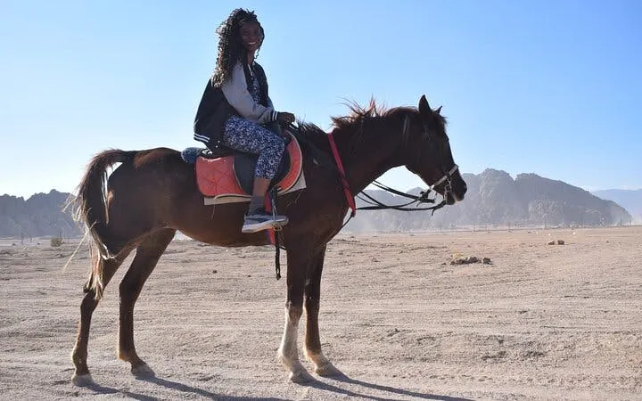 Horseback rider in desert near Sharm El Sheikh with mountains in background.