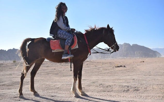 Horseback rider in desert near Sharm El Sheikh with mountains in background.