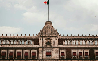 Historic building facade with Mexican flag in Mexico City's Centro Histórico.