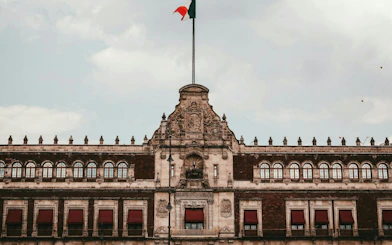 Historic building facade with Mexican flag in Mexico City's Centro Histórico.