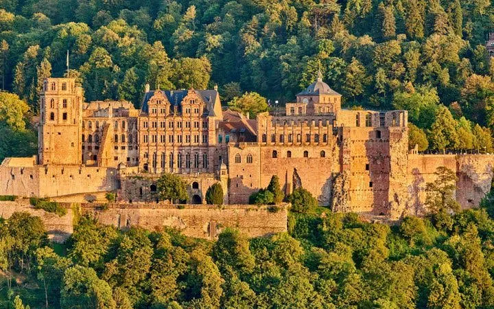 Heidelberg Castle surrounded by lush greenery, featured in self-guided walking tour app.