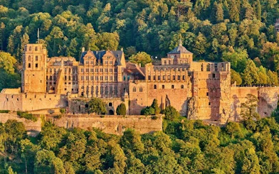 Heidelberg Castle surrounded by lush greenery, featured in self-guided walking tour app.