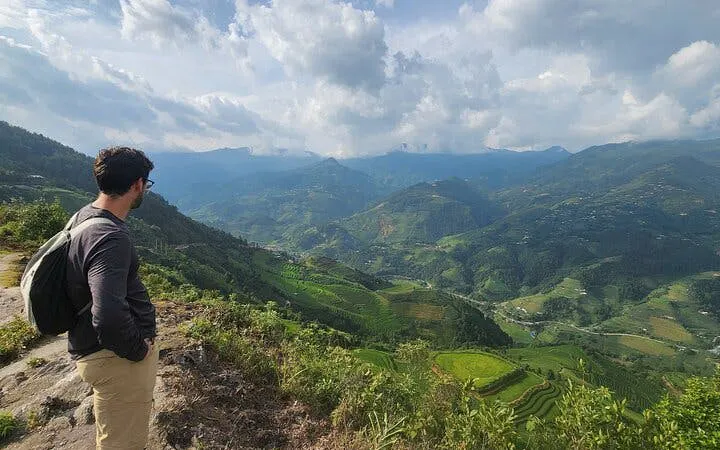 Man overlooking terraced rice fields in Mu Cang Chai during trekking tour.