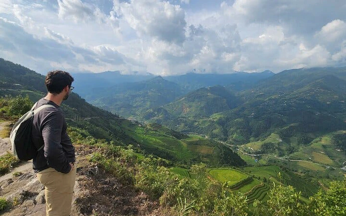 Man overlooking terraced rice fields in Mu Cang Chai during trekking tour.