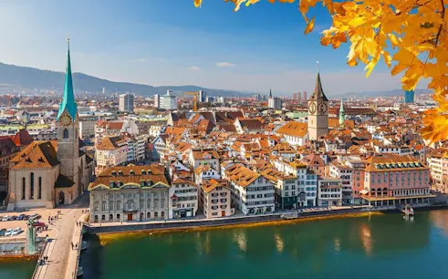Zurich cityscape with river view and historic churches on a sunny day.