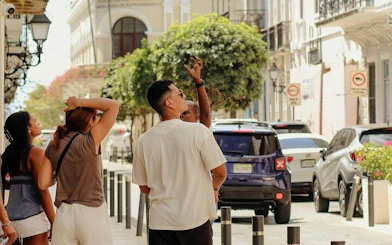 Tourists exploring the streets of Santo Domingo's Colonial Zone with a guide pointing out landmarks.