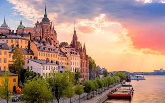 Stockholm waterfront with historic buildings and sunset sky during a walking tour.