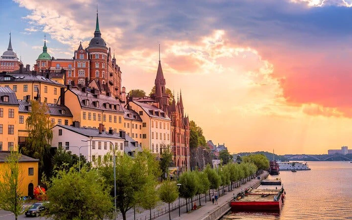 Stockholm waterfront with historic buildings and sunset sky during a walking tour.