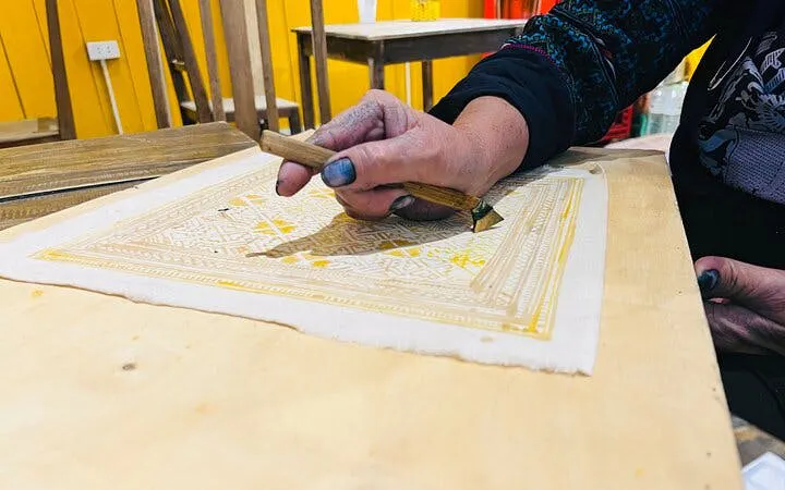 H’Mong artisan creating batik design with beeswax in Sa Pa workshop.