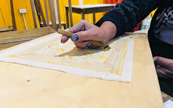 H’Mong artisan creating batik design with beeswax in Sa Pa workshop.