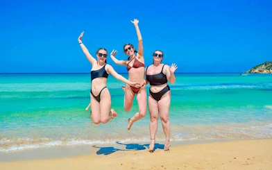 Tourists enjoying Macao Beach in Punta Cana with clear blue water in the background.