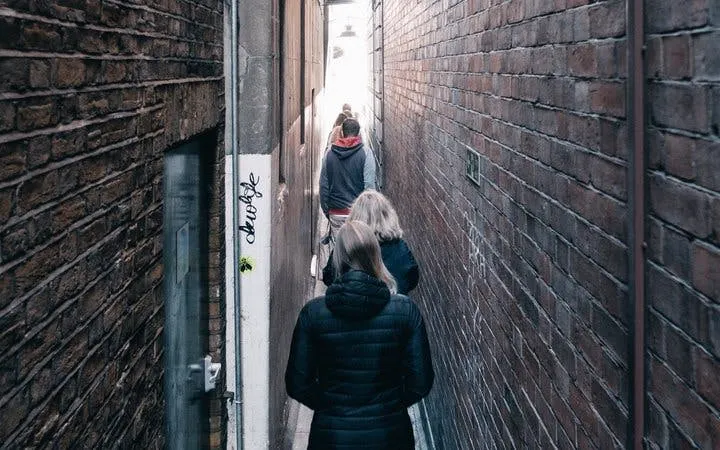 Walking tour group in narrow alley during Little Venice ghost walk.