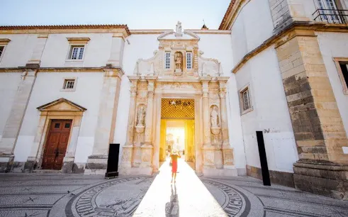 Coimbra University entrance with sunlight streaming through the archway.