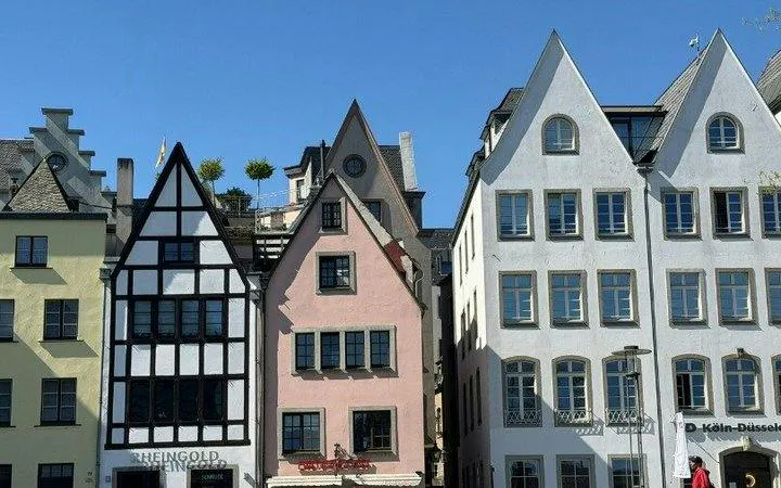 Colorful historic buildings in Cologne's Old Town on a sunny day.