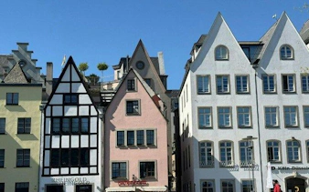 Colorful historic buildings in Cologne's Old Town on a sunny day.