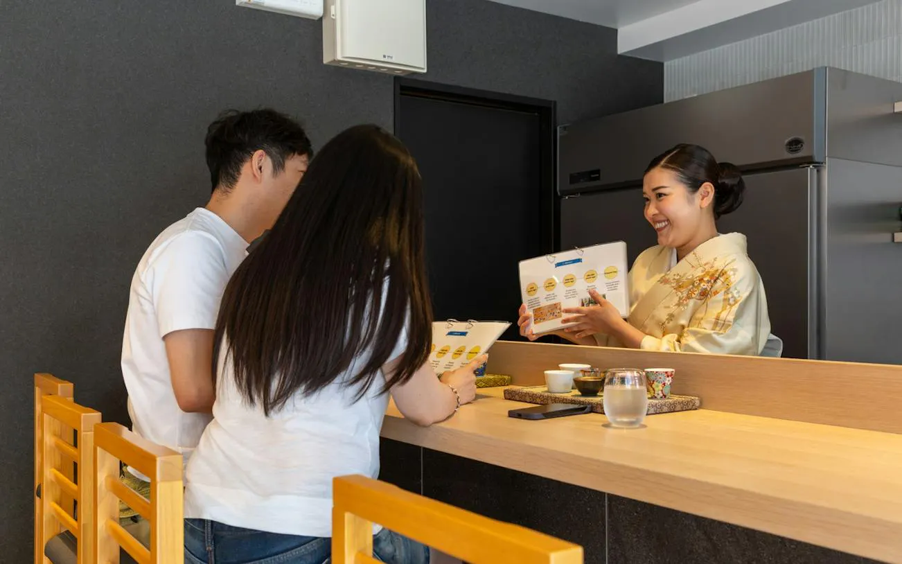 Sake sommelier explaining tasting notes to guests in Kyoto.