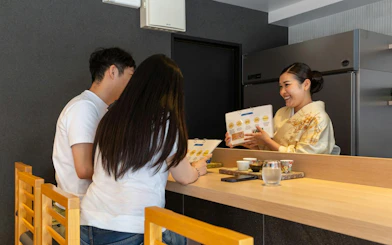 Sake sommelier explaining tasting notes to guests in Kyoto.