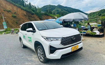 Private car parked on a scenic roadside in a mountainous area, available for full-day rental with driver.