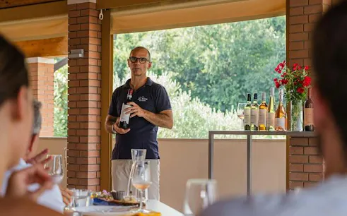 Man presenting wine bottles during Bardolino Vineyard Tour, Lake Garda.