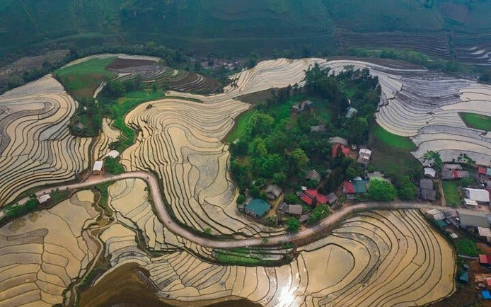 Sapa terraced rice fields with village and winding road, Vietnam.