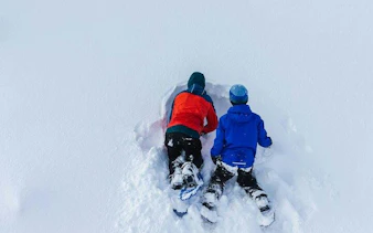 Children snowshoeing in deep snow during Lapland tour, Rovaniemi.